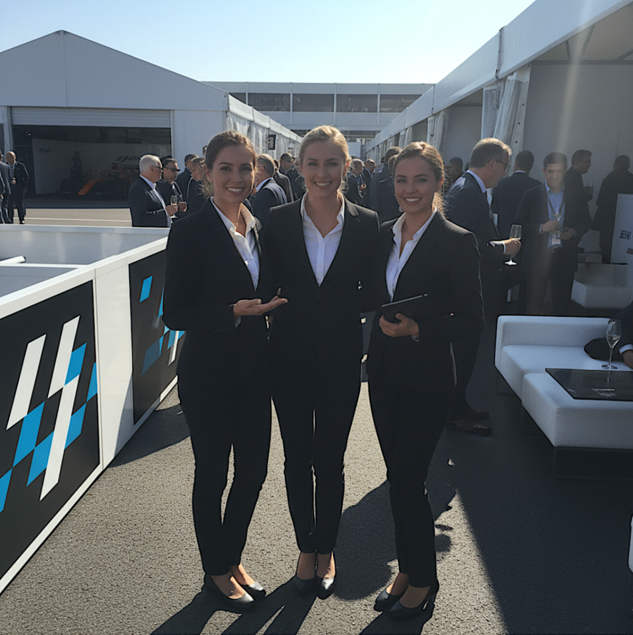 VIP hosts in black tailoring at a premium outdoor event